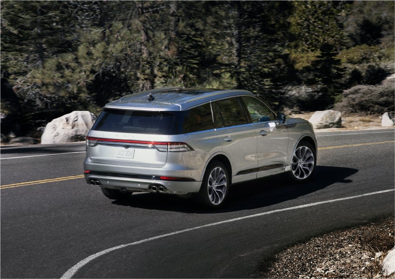 A 2023 Lincoln Aviator® Grand Touring model is shown being driven on a tight turn of a mountain road | Parkway Lincoln in Winston Salem NC