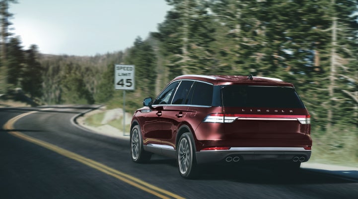 A 2024 Lincoln Aviator® SUV is being driven on a winding mountain road | Parkway Lincoln in Winston Salem NC