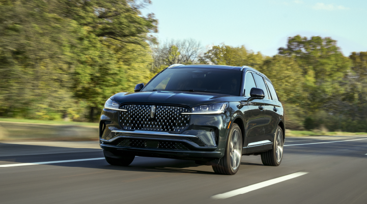 A 2025 Lincoln Black Label Aviator® SUV is being driven down a road lined with trees. | Parkway Lincoln in Winston Salem NC