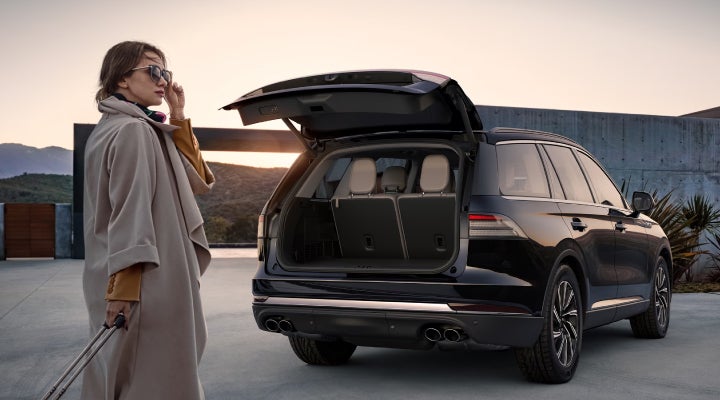 A woman approaches a 2026 Lincoln Aviator® SUV with its rear liftgate open. | Parkway Lincoln in Winston Salem NC