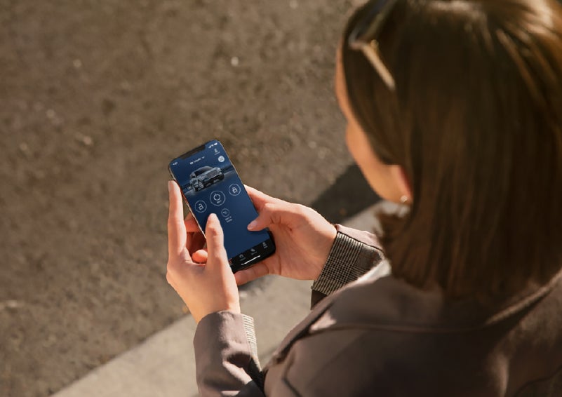 A person is shown interacting with a smartphone to connect to a Lincoln vehicle via the Lincoln Way® app. | Parkway Lincoln in Winston Salem NC
