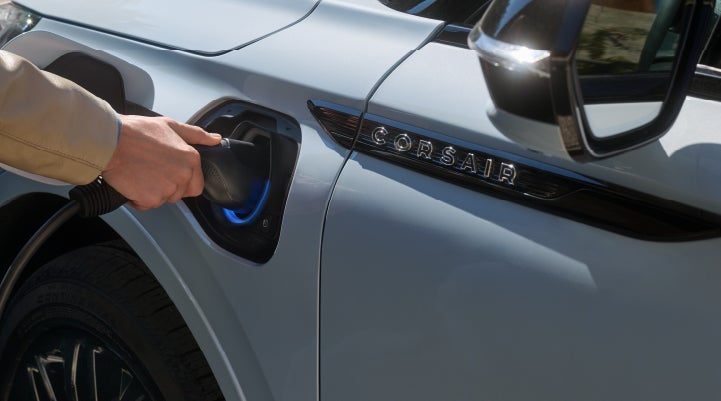 A hand is plugging in a 2026 Lincoln Corsair® Grand Touring Plug-in Hybrid SUV. | Parkway Lincoln in Winston Salem NC