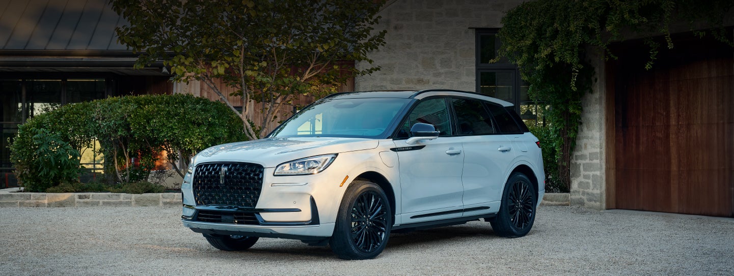 A 2026 Lincoln Corsair® SUV is parked in front off a luxury home. | Parkway Lincoln in Winston Salem NC