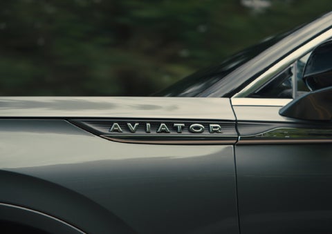 The driver’s side door and fender badging of a gray 2027 Lincoln Aviator® SUV are showcased. | Parkway Lincoln in Winston Salem NC